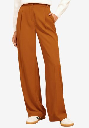 Brede broek in een warme oranje tint, gemaakt van glad stof. Voorzien van twee voorkanten zakken en een geplooid ontwerp voor extra detail.