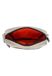 Borsa in tela di un beige chiaro con zip nera. Interno foderato di un arancione vivace, con un ampio scomparto e una superficie liscia.