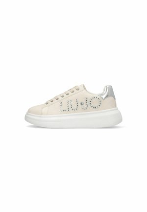 Zapatillas blancas con parte superior de cuero liso, detalles plateados en el talón y logo con tachuelas en el costado. Suela blanca gruesa.