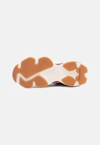 Rubber athletic shoe sole with a textured, cushioned design. Predominantly white with brown accents and a star-shaped pattern.