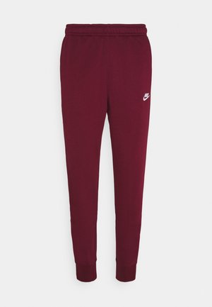 Pantalones de chándal maroon de Nike con cintura elástica, piernas ajustadas, tobillos ceñidos y pequeño logo blanco de Nike en el muslo izquierdo.
