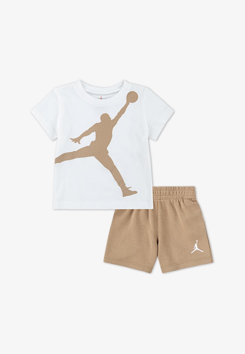 Weißes Baumwoll-T-Shirt mit einer braunen Silhouette eines Spielers, der zum Korbwurf abspringt. Kombiniert mit beigen Shorts mit elastischem Bund und geprägt mit Logo.