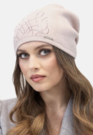 Helles rosa gestrickte Mütze mit geripptem Muster, das ein Blattmuster aufweist und ein silbernes Markenschild an der Seite hat. Weiches, lässiges Design.