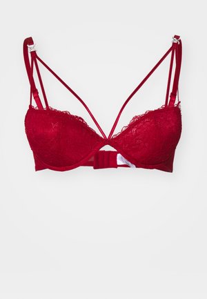 Soutien-gorge en dentelle rouge avec des bonnets rembourrés, des détails en dentelle complexe le long des bords, des bretelles réglables et une fermeture à crochets au dos.