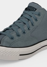 Γκρι Converse sneaker με ύψος πάνω στον αστράγαλο, με ταιριαστά κορδόνια, μεταλλικά οπές και λευκή καουτσούκ σόλα με μαύρη λωρίδα.