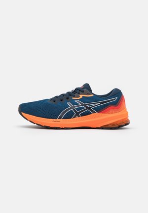 Chaussure de course bleue et orange avec des lacets noirs, un logo blanc sur le côté et une semelle amortissante appelée FlyteFoam, vue de la face extérieure.
