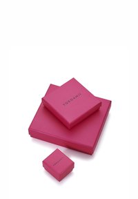 Różowe pudełka prezentowe w różnych rozmiarach ułożone jedno na drugim. Na górnym pudełku widnieje napis "YOKOAMII" prostą czcionką. Gładka, błyszcząca tekstura.