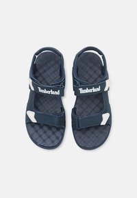 Sandalias azul marino con tiras ajustables, que cuentan con una suela texturizada y acentos de logo en blanco. Fabricadas con materiales duraderos para mayor comodidad.