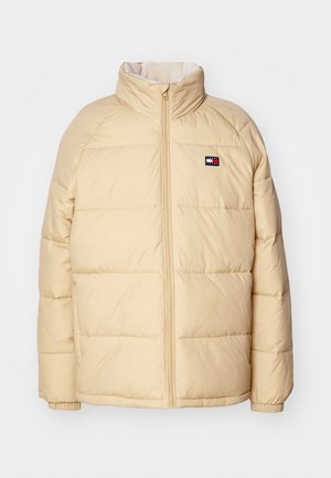 Beige puffer jacket with a high collar, zip front, quilted design, and elastic cuffs. Features a small logo emblem on the left chest.