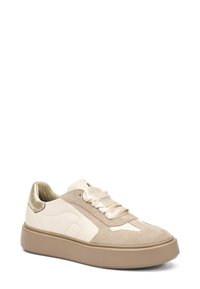 Sneaker in suede beige e pelle crema con un'accennata dorata metallica, lacci in satin e una robusta suola in gomma beige. Punta tondeggiante e dettaglio laterale testurizzato.
