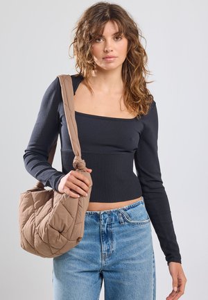 Schwarzes, geripptes Langarmshirt mit quadratischem Ausschnitt, kombiniert mit hellblauen High-Waist-Jeans und einer gesteppten beigen Schultertasche.