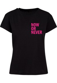 Tricou din bumbac negru cu un grafic îndrăzneț roz care spune "ACUM SAU NICIODATĂ" vertical pe partea stângă. Design cu mâneci scurte și gât rotund.