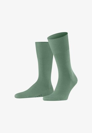 Paar hellgrüne, knielange Socken mit gerippten Bündchen, vor weißem Hintergrund dargestellt.