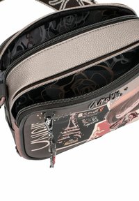 Borsa a tracolla multi-scomparto con un'esterno grigio testurizzato, fodera a fantasia, hardware argentato e un tirazip decorativo.
