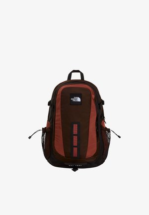 Brun og rust rød North Face rygsæk med flere rum, net-lomme på siden og håndtag i toppen.