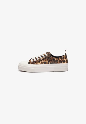 Sneakers z płótnem w cętkowaną panterę, z białą gumową podeszwą i noskiem, z białymi sznurówkami i czarnym wnętrzem. Zapięcie na zapiętek z tyłu.