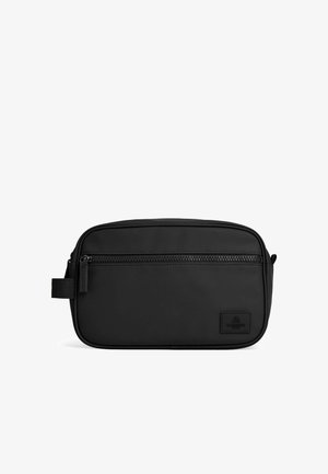 Trousse de toilette rectangulaire noire avec poche zippée à l'avant et poignée latérale, fabriquée en matière lisse avec un petit patch logo de la marque.