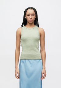 Haut débardeur côtelé vert clair avec un col rond, associé à une jupe en satin bleue. Le tissu est lisse avec une silhouette ajustée.