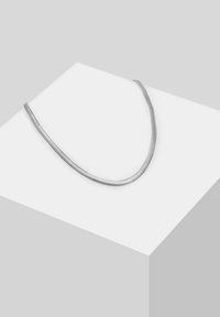 Sølv slangesmykke, med et glat, fleksibelt design i herringbone-mønster, som ligger på en neutral overflade.