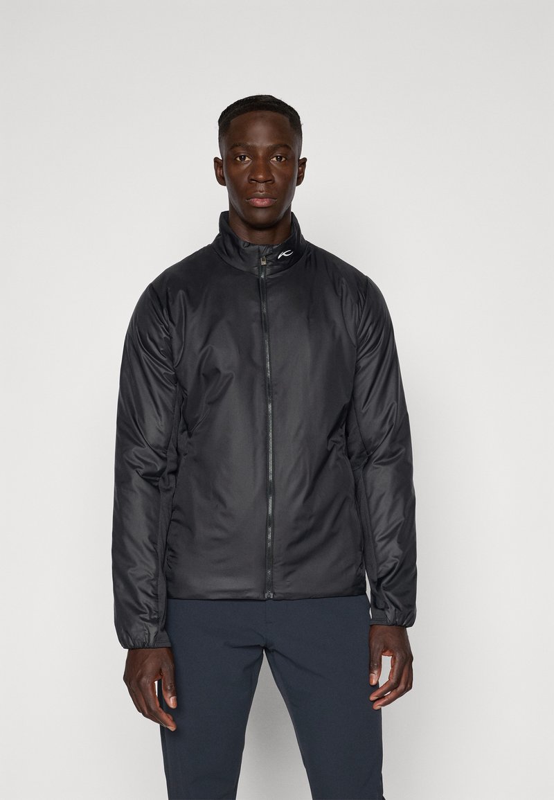 Black padded jacket with a high collar, front zipper, and elastic cuffs. Features a smooth, shiny texture and logo on the collar.
