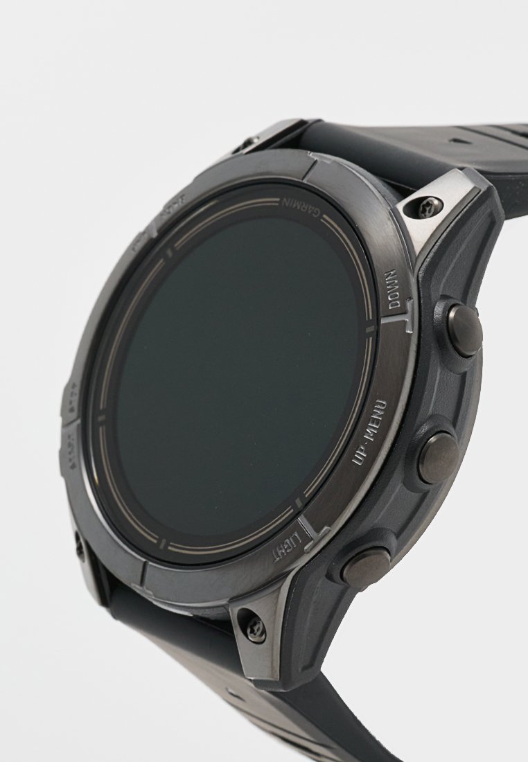 Reloj inteligente negro con una cara circular, bisel de metal texturizado y correa de goma. Cuenta con varios botones laterales para funcionalidad.