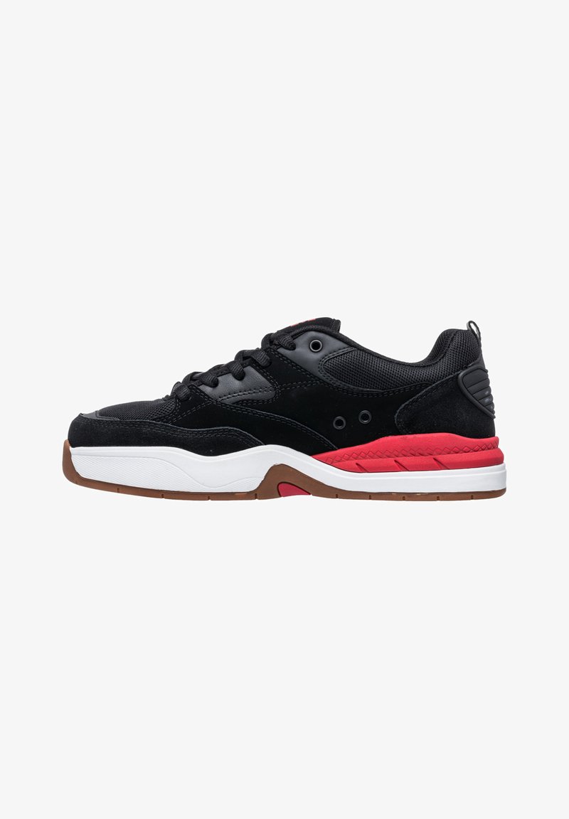 Black athletic shoes featuring a mix of suede and mesh, a red accent on the midsole, and a brown rubber outsole with a textured pattern.
