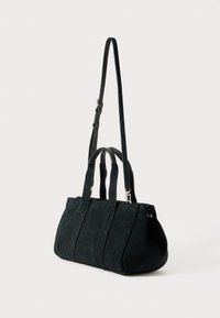 Schwarze Wildleder-Tote mit strukturierter Form, ausgestattet mit zwei oberen Griffen und einem verstellbaren Schultergurt. Glatte Textur, minimale Hardware-Details.