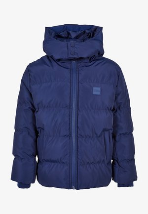 Tamsiai mėlynas pūkinis džemperis su aukštu apykakle, užtrauktuku priekyje ir dviem šoninėmis kišenėmis. Yra elastingi rankogaliai ir logotipo pritvirtinimas ant krūtinės.