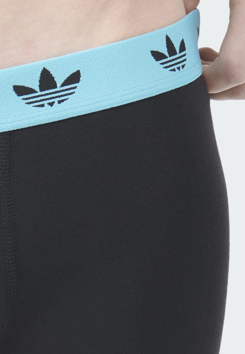 Schwarze Leggings mit einem hellblauen elastischen Bund, der ein schwarzes dreiblättriges Logo und drei Streifen zeigt, mit einer glatten Textur.