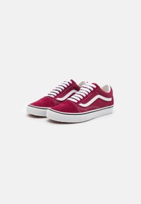 Rød semsket sneakers med hvite snøring og detaljer, med et klassisk design og en svart gummisåle. Akser inkluderer en bølget side stripe.