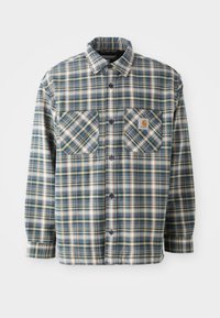 Button-up flannel skjorte i blå, grøn og cremefarvet tern. Har to brystlommer, rund krave og mørke knapper. Fremstillet af bomuldsstof.