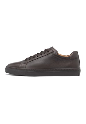 Dunkelbrauner flacher Ledersneaker mit passenden Schnürsenkeln und strukturierter Gummisohle, von der Innenseite auf weißem Hintergrund betrachtet.