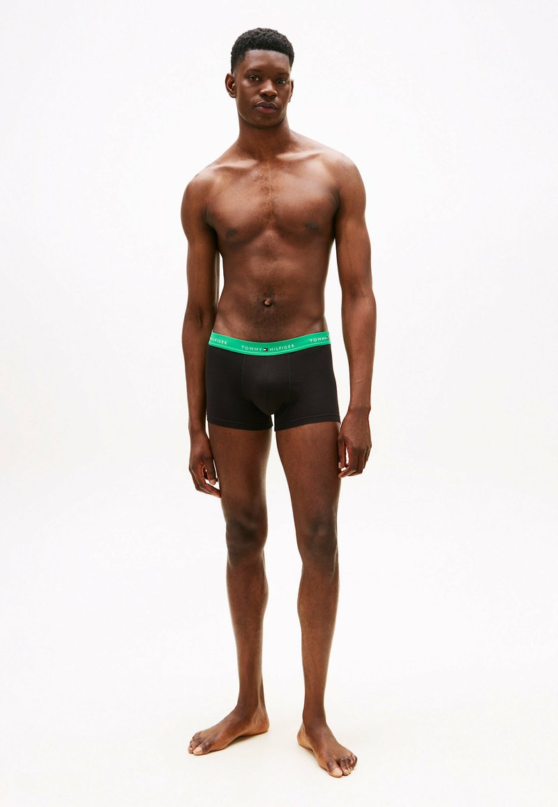 Sorte bomulds boxer briefs med en grøn, mærket elastisk talje. Tætsiddende design, glat tekstur og længde til midt på låret.
