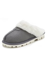 Gray suede slipper with a white faux fur cuff, featuring a rounded toe and a white rubber sole with a textured grip pattern.