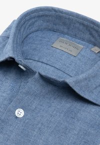 Niebieska, w paski koszula dżinsowa z kołnierzykiem z guzikami, z metalową metką z napisem „DAN JOHN REGULAR” oraz białym guzikiem.