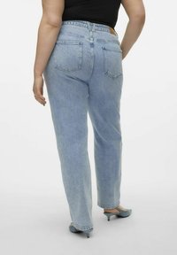 Ljusblå hög midja jeans med rak benform, som har två bakfickor och en platt midja. Bärs med blå klackskor.
