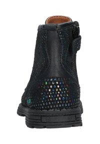 Botas de tobillo negras con cuero texturizado, adornadas con destellos multicolores. Cuentan con puntera redondeada, cremallera trasera y suela de goma resistente.