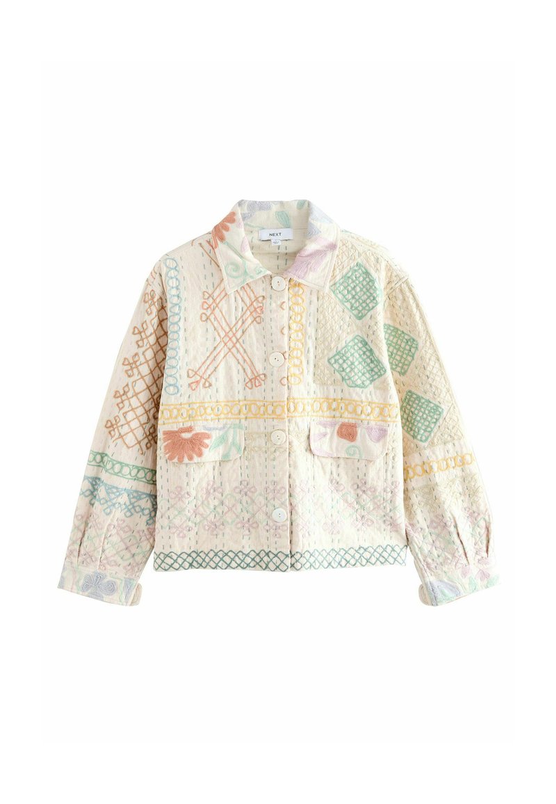 Lichtbeige jasje met knopen, versierd met pastel geometrische en bloemmotieven, met een kraag en twee voorzakken.