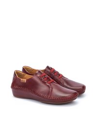 Zapatos de cuero rojo con un acabado suave, punta redondeada y diseño de cordones. Presentan detalles cosidos a lo largo de los costados y un tacón bajo.