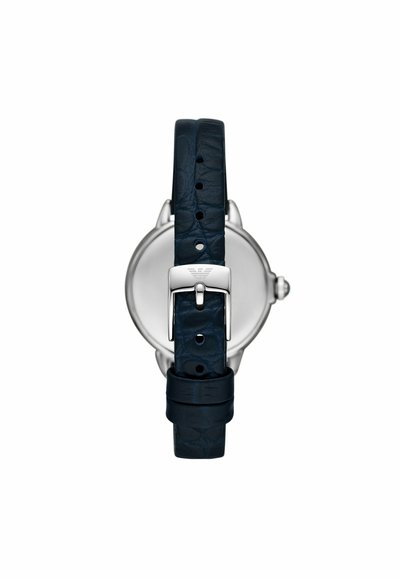 Reloj de acero inoxidable plateado con una correa de cuero azul oscura que presenta un acabado texturizado y una hebilla plateada. Diseño minimalista con una esfera redonda.