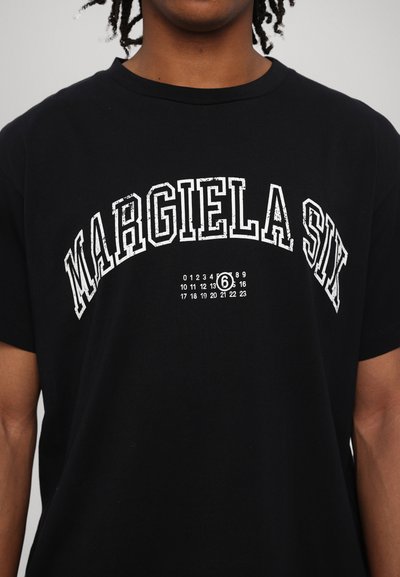 Fekete pamut póló, fehér, texturált felirattal a "MARGIELA SIX" szöveggel, alatta számokkal. Kerek nyakkivágású és rövid ujjú.