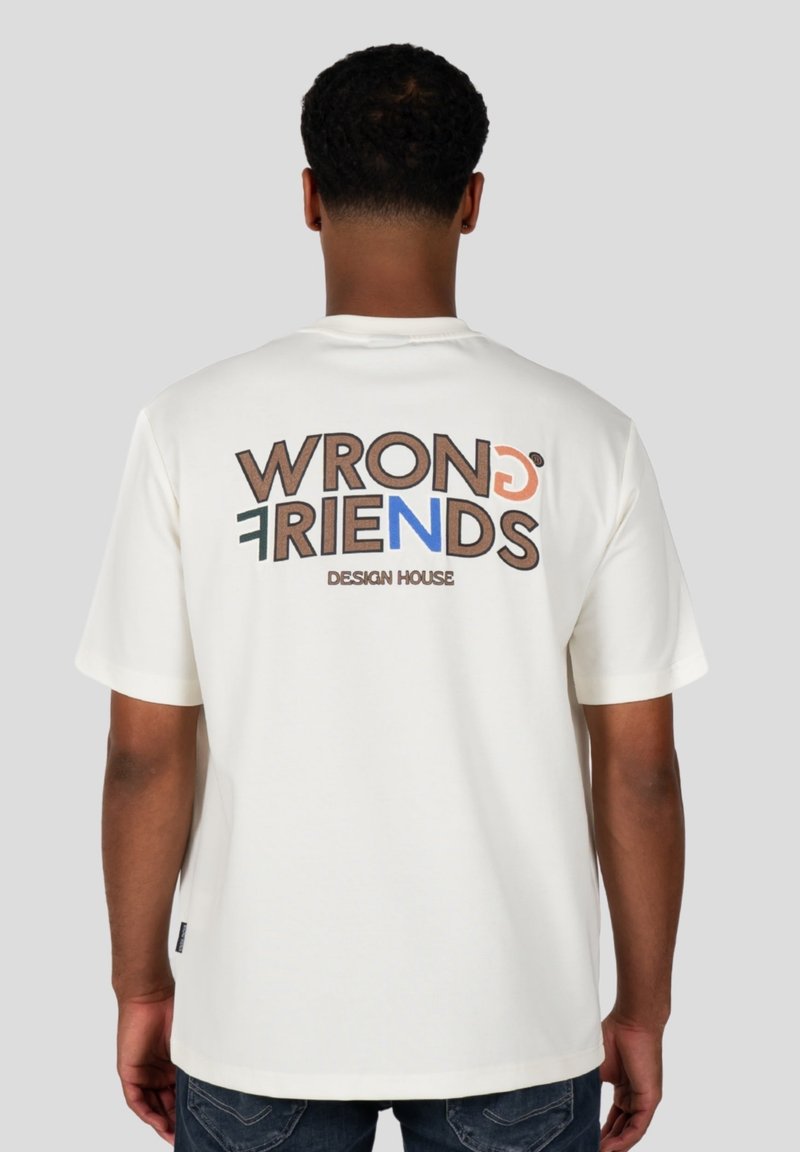 Biała bawełniana koszulka z krótkim rękawem, z kolorowym napisem "WRONG FRIENDS" i "DESIGN HOUSE" nadrukowanym na plecach.