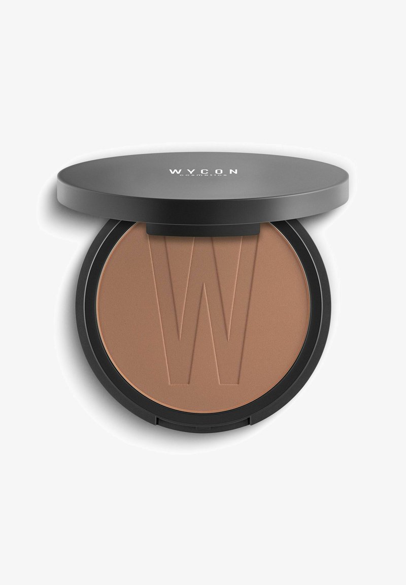 Bronzer compatto con una texture liscia e opaca. Caratterizzato da una tonalità abbronzata e il logo "W" in rilievo. Scatola circolare nera con coperchio piatto.