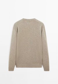 Beige knit sweater, long sleeves, ribbed cuffs and hem, crew neckline, soft texture, minimal design, uniform appearance.