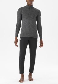Szary długi rękaw sportowy top z pół zamkiem i strukturalnymi paskami, w połączeniu z czarnymi dopasowanymi spodniami z delikatnym wzorem kratki i logo.