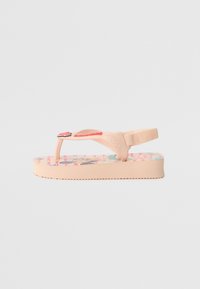 Chinelo de borracha rosa com uma sola texturizada, padrões florais na palmilha e um detalhe em forma de coração na tira.