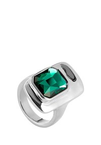 Anillo en tono plateado con una gran piedra rectangular facetada de color verde esmeralda, con una banda lisa y pulida y acentos de diseño curvado.