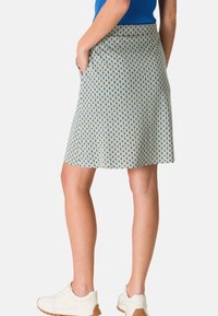 Une jupe trapèze à motifs aux tons bleu clair, beige et vert, dotée de poches latérales et d'une ceinture confortable.