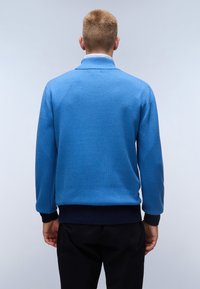 Maglione azzurro a maglia con colletto alto e polsini a coste blu scuro. Texture semplice senza motivi, visto da dietro su uno sfondo chiaro.
