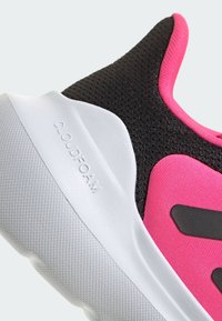 Black and pink athletic shoe featuring a textured upper, a white Cloudfoam midsole, and a smooth rubber outsole with patterned grip.